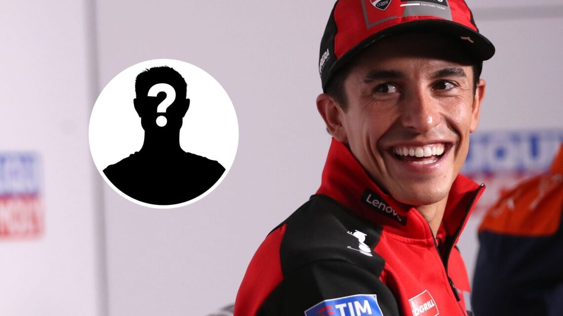 Marc Marquez laughing in a press conference with a mystery image next to him.