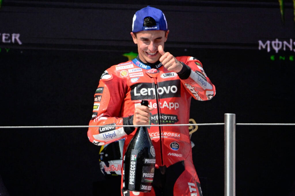 Marc Marquez of Ducati gives a thumbs up while holding champagne on the Catalan Grand Prix podium