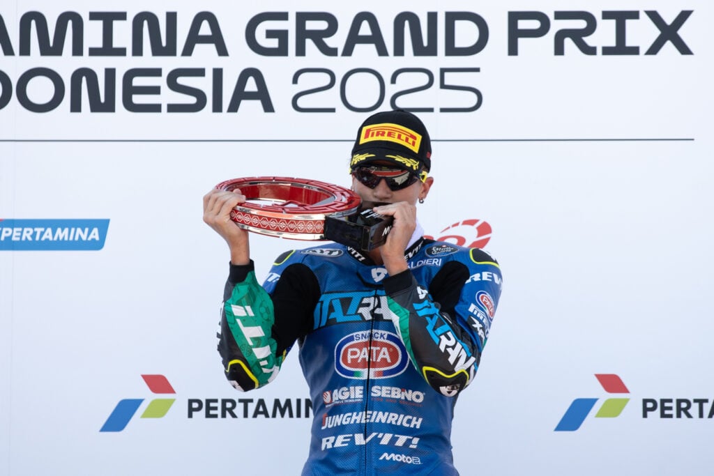 Italtrans rider Diogo Moreira kisses his trophy on the Mandalika podium after winning the 2025 Moto2 Indonesian Grand Prix