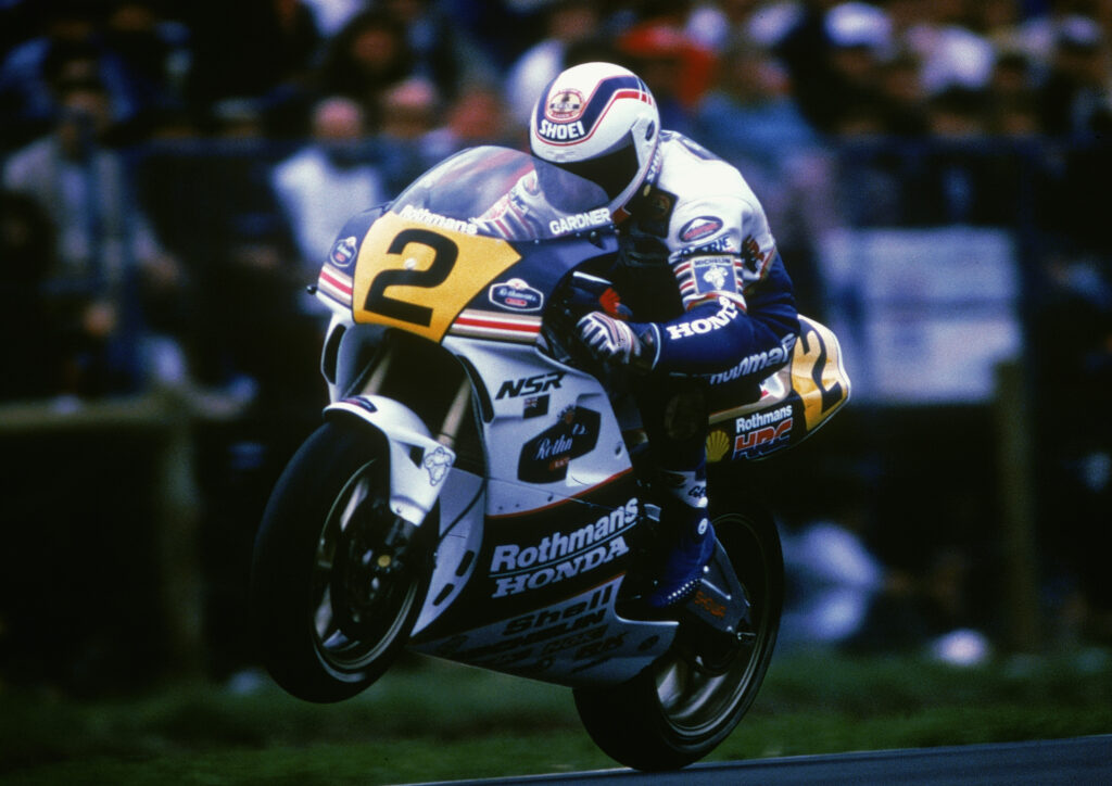 Wayne Gardner performs a wheelie on his Rothmans Honda motorcycle after winning the 1989 Australian Grand Prix