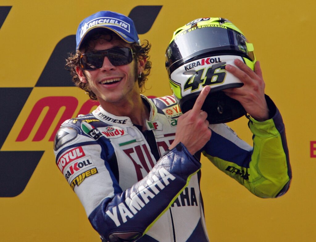 Valentino Rossi points to his helmet and smiles after winning the Grand Prix of Portugal
