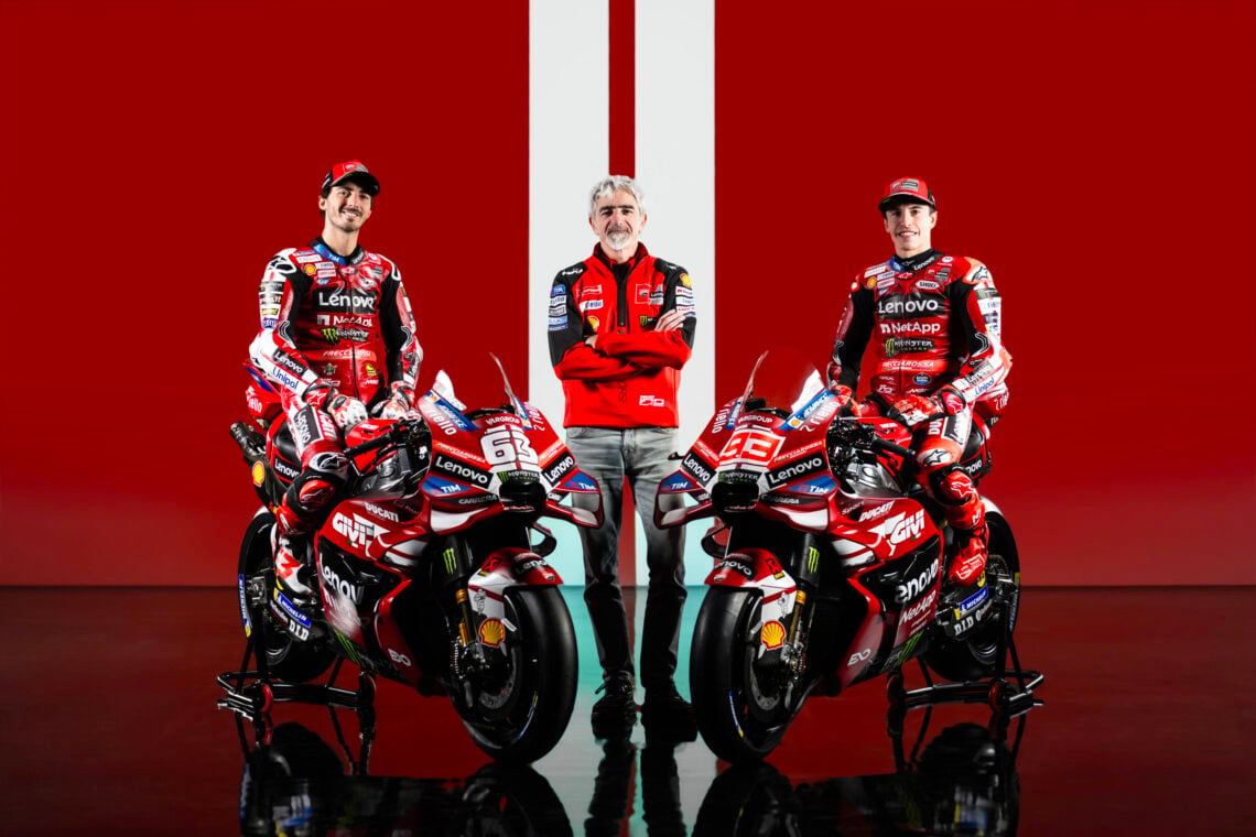Luigi Dall'Igna, Francesco Bagnaia and Marc Marquez pose with the 2026 Ducati bikes