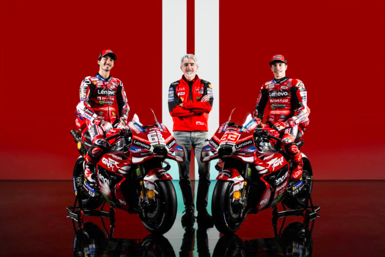 Luigi Dall'Igna, Francesco Bagnaia and Marc Marquez pose with the 2026 Ducati bikes