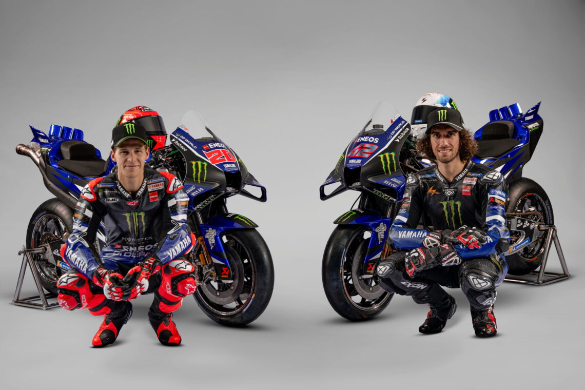 Fabio Quartararo and Alex Rins pose with the new 2026 V4 Yamaha M1 in a studio