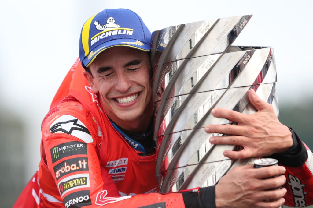 Ducati rider Marc Marquez hugs the MotoGP trophy after winning the 2025 title in Japan.