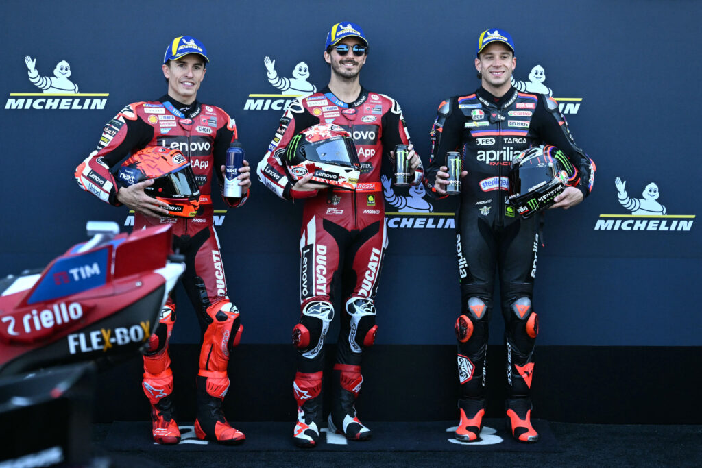 Ducati's Francesco Bagnaia celebrates scoring pole for the 2026 MotoGP French Grand Prix with Marc Marquez and Marco Bezzecchi in parc ferme