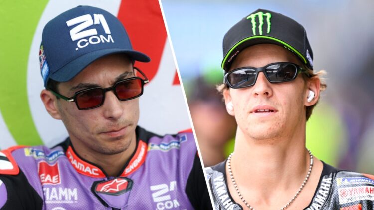 Toprak Razgatlioglu of Pramac sits on the pit wall; Fabio Quartararo of Yamaha walks in the pit lane