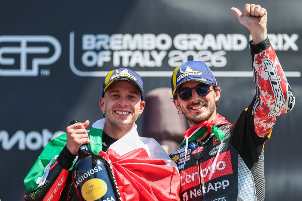 Aprilia rider Marco Bezzecchi celebrates with Ducati's Francesco Bagnaia on the Mugello podium after the 2026 MotoGP Italian Grand Prix.