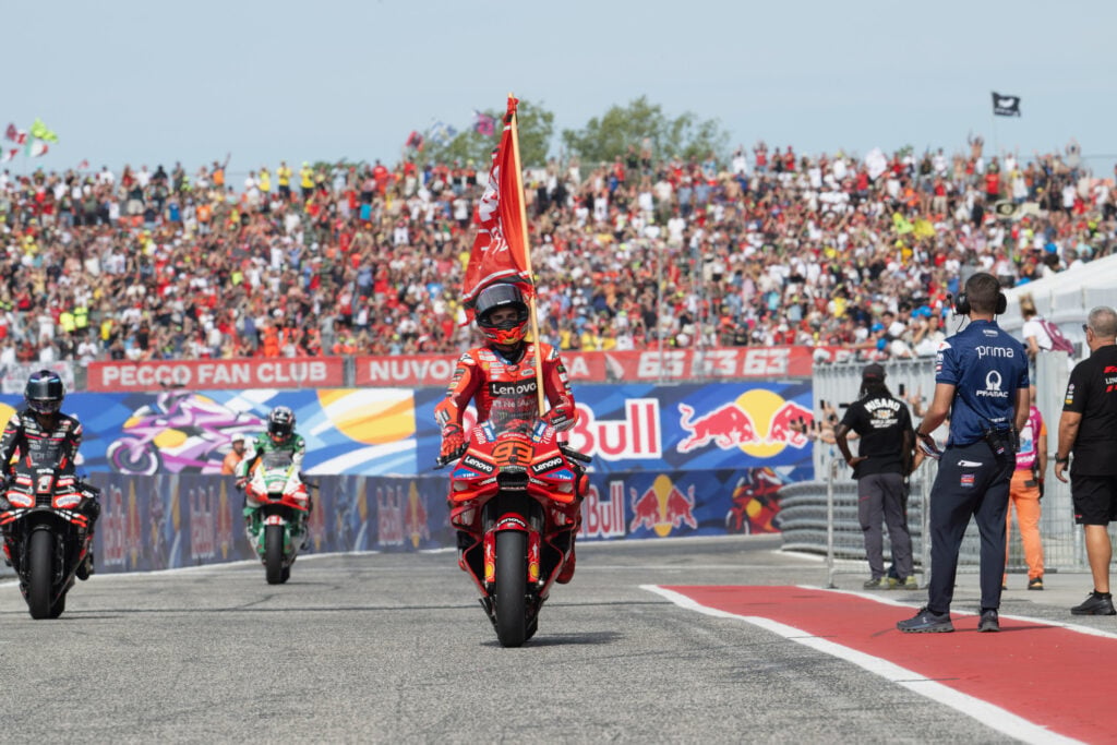 Marc Marquez of Ducati celebrates his win at the San Marino Grand Prix with a Spanish Flag.